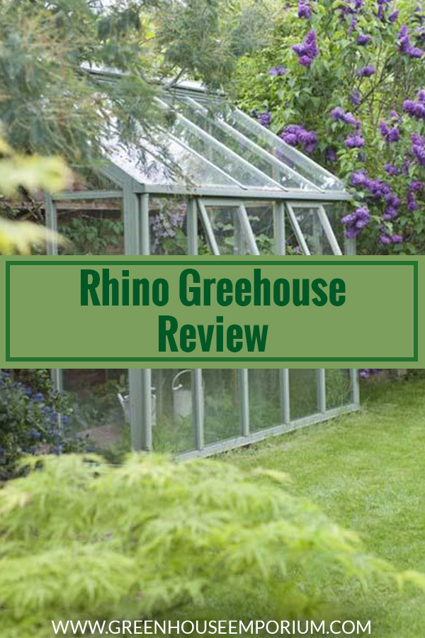 Greenhouse with white frame in a garden and the text: Rhina Greenhouse Review